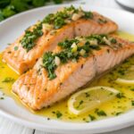 Seared salmon fillets with lemon slices and fresh parsley in lemon butter sauce